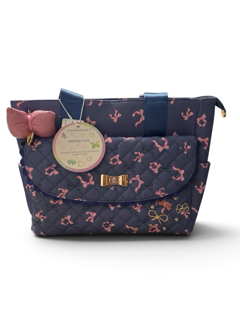Under 1 Sky quilted dark blue tote bag featuring a charming pink and gold bow